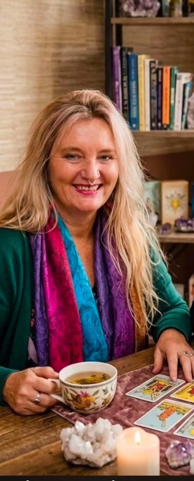 Nic smiling with tea and tarot cards in her practice